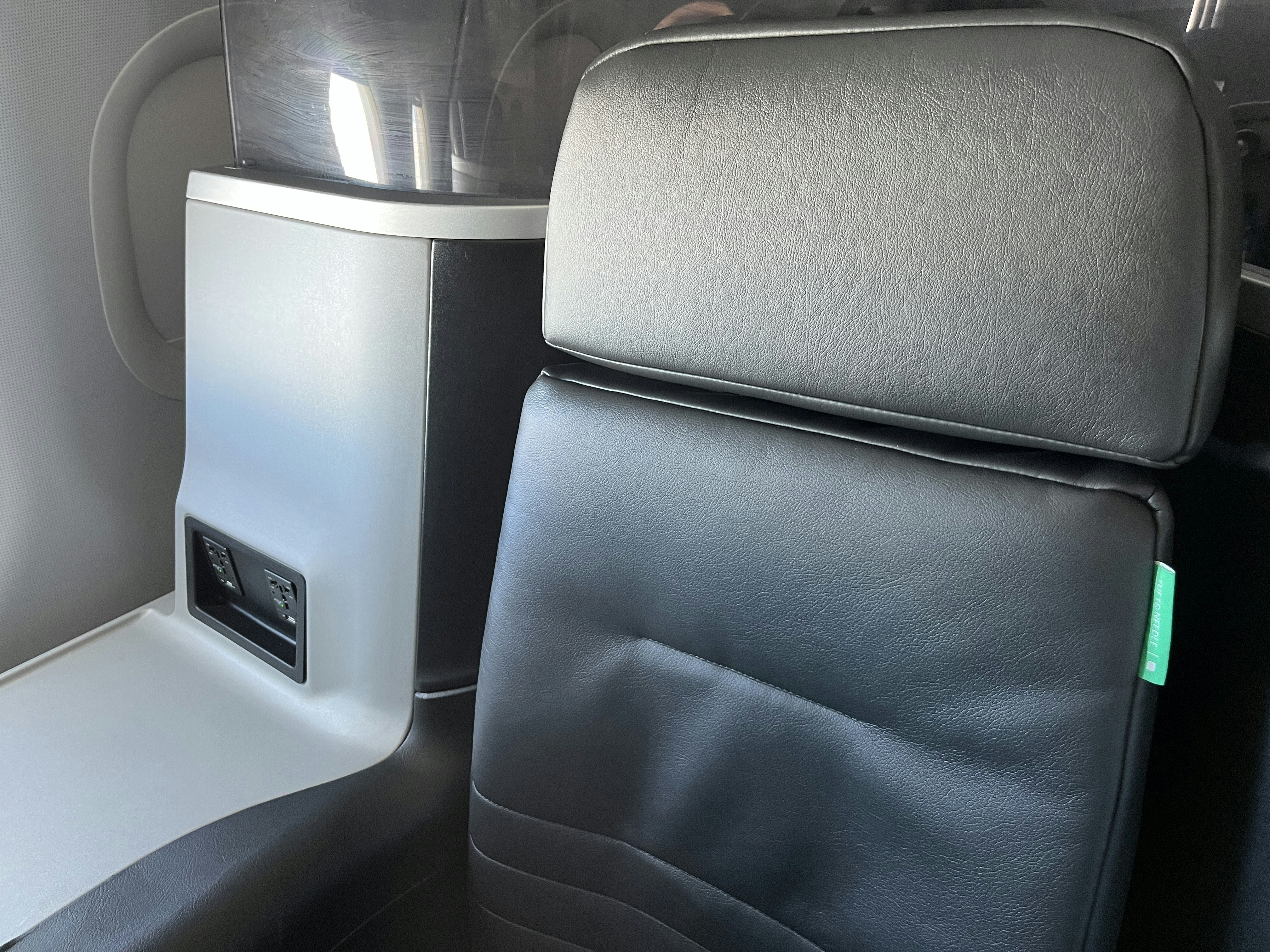 a seat in an airplane with a cup holder, JetBlue Mint business class seat.