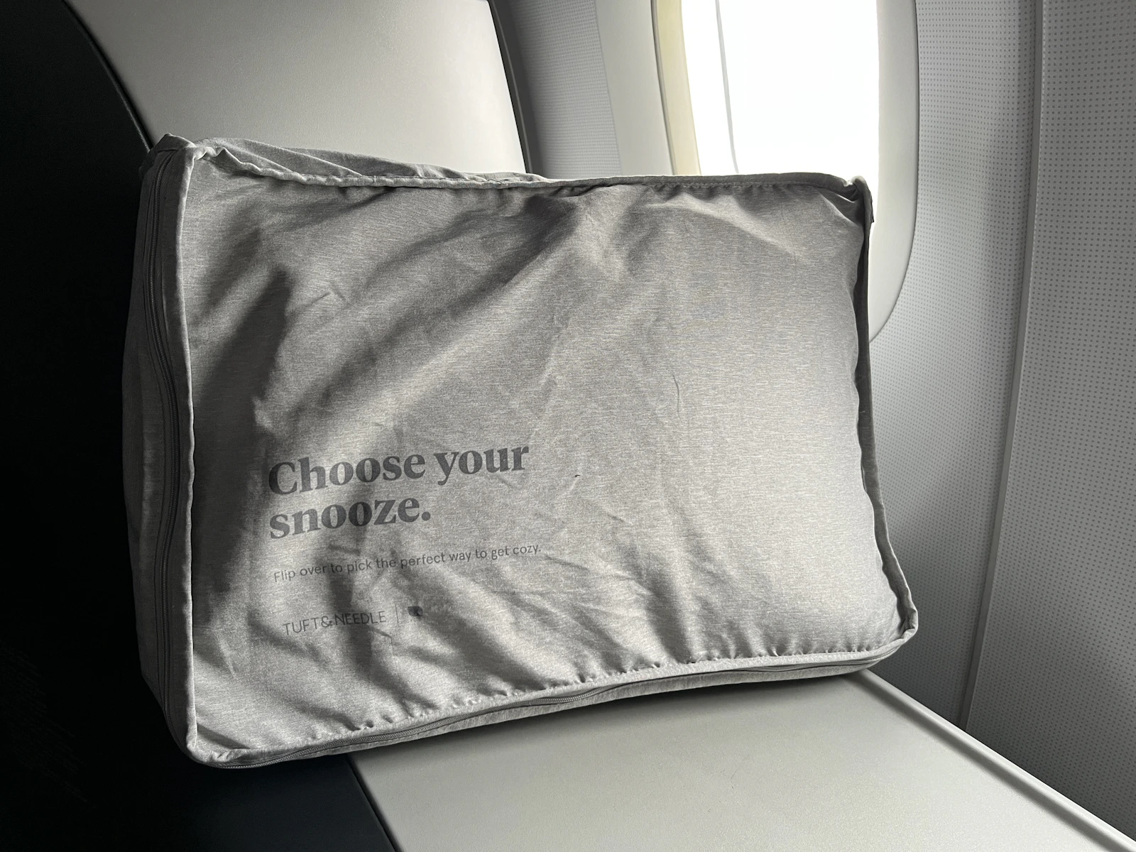 Airplane seat with a soft travel pillow prepared for a comfortable flight