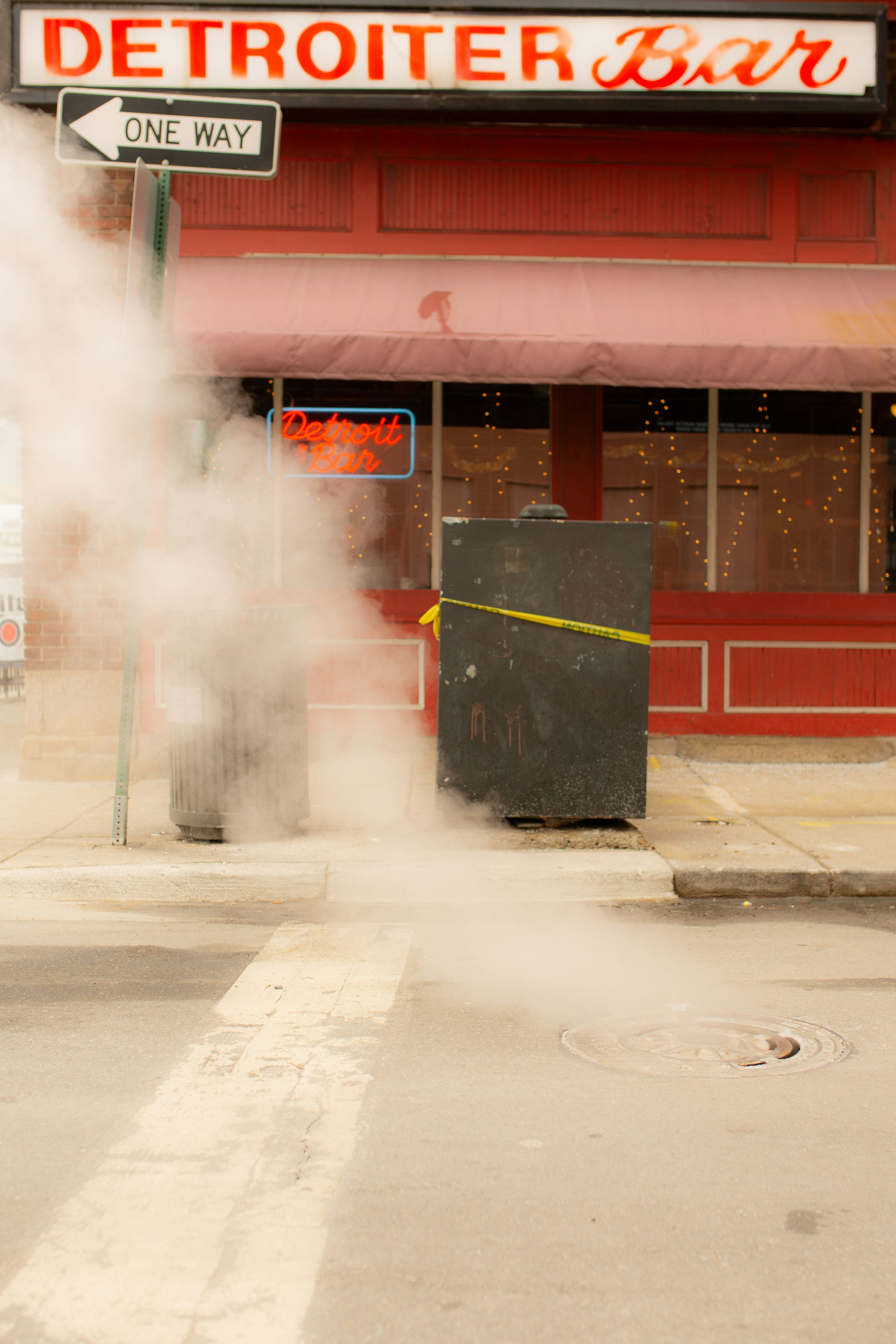 a street sign with steam coming out of it