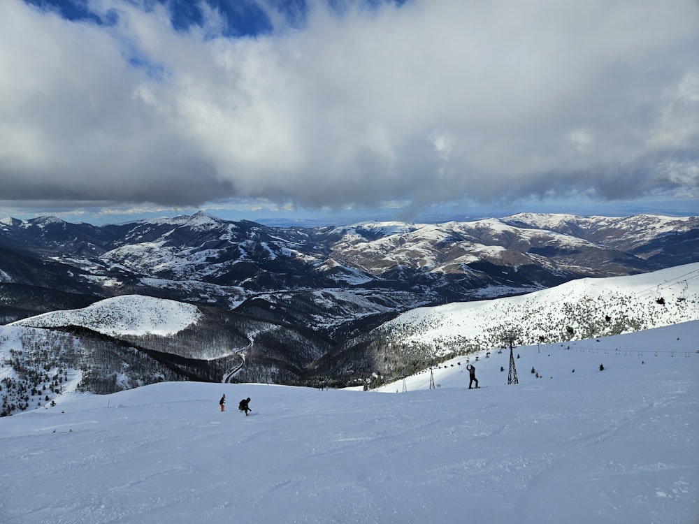 a group of people riding skis on top of a snow covered slope