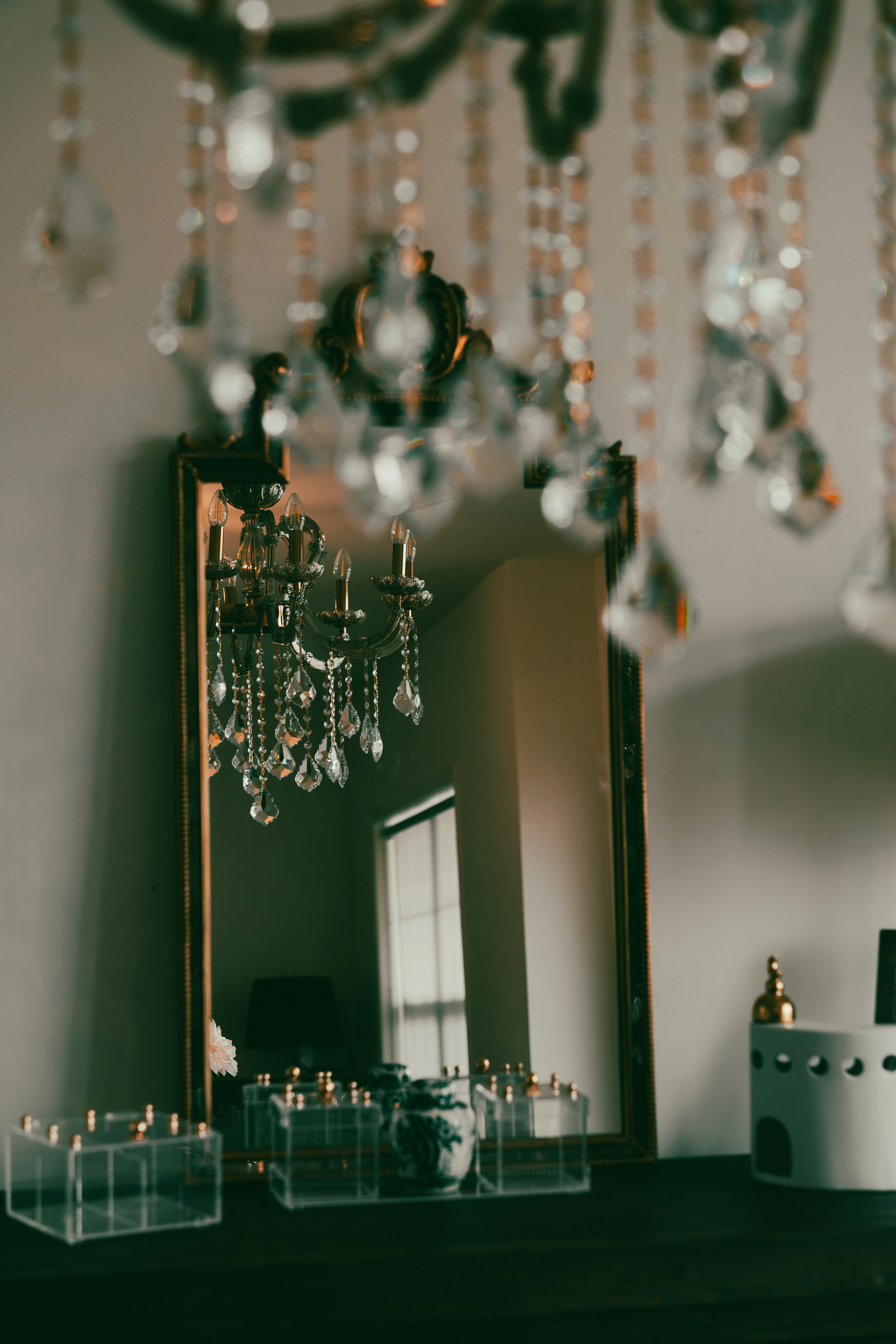 a chandelier hanging from a ceiling next to a mirror