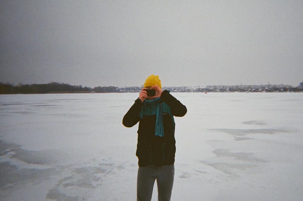 a person standing in the snow taking a picture