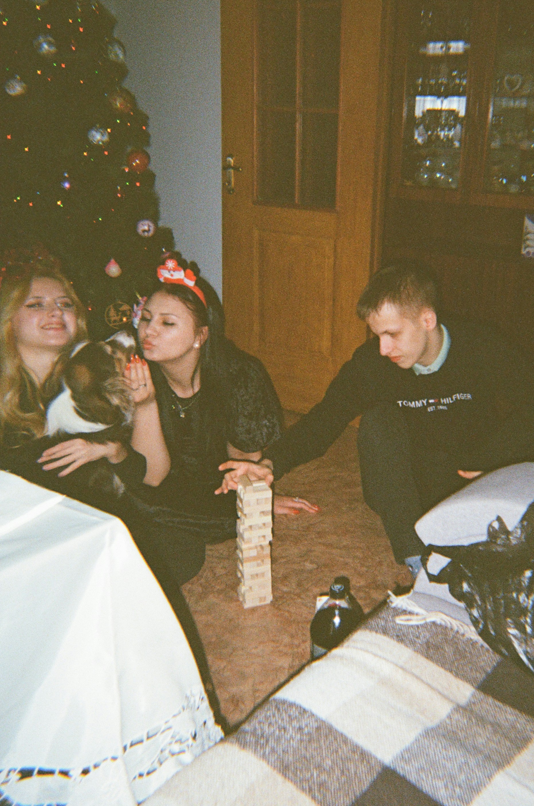 a group of people sitting around a christmas tree