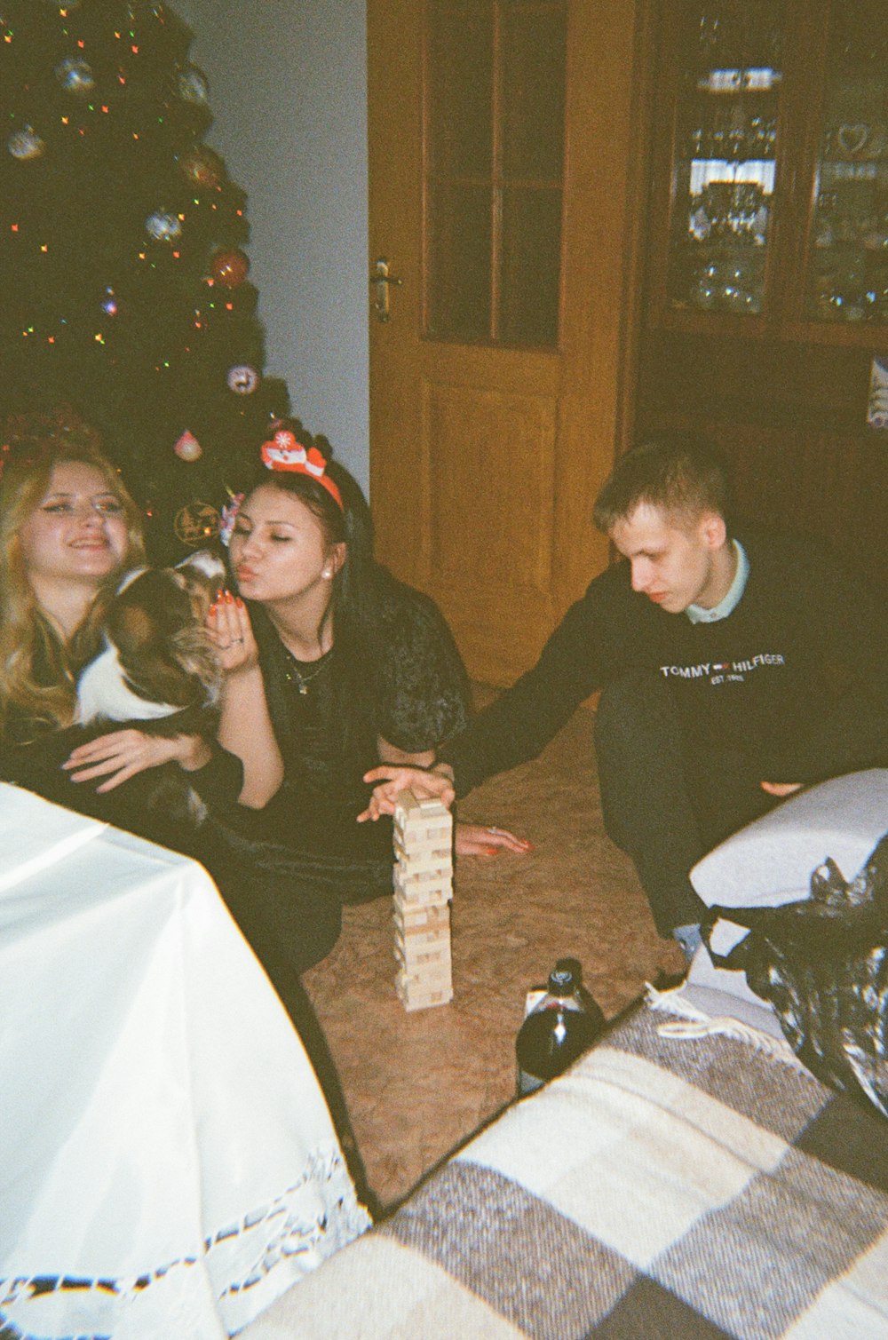 a group of people sitting around a christmas tree