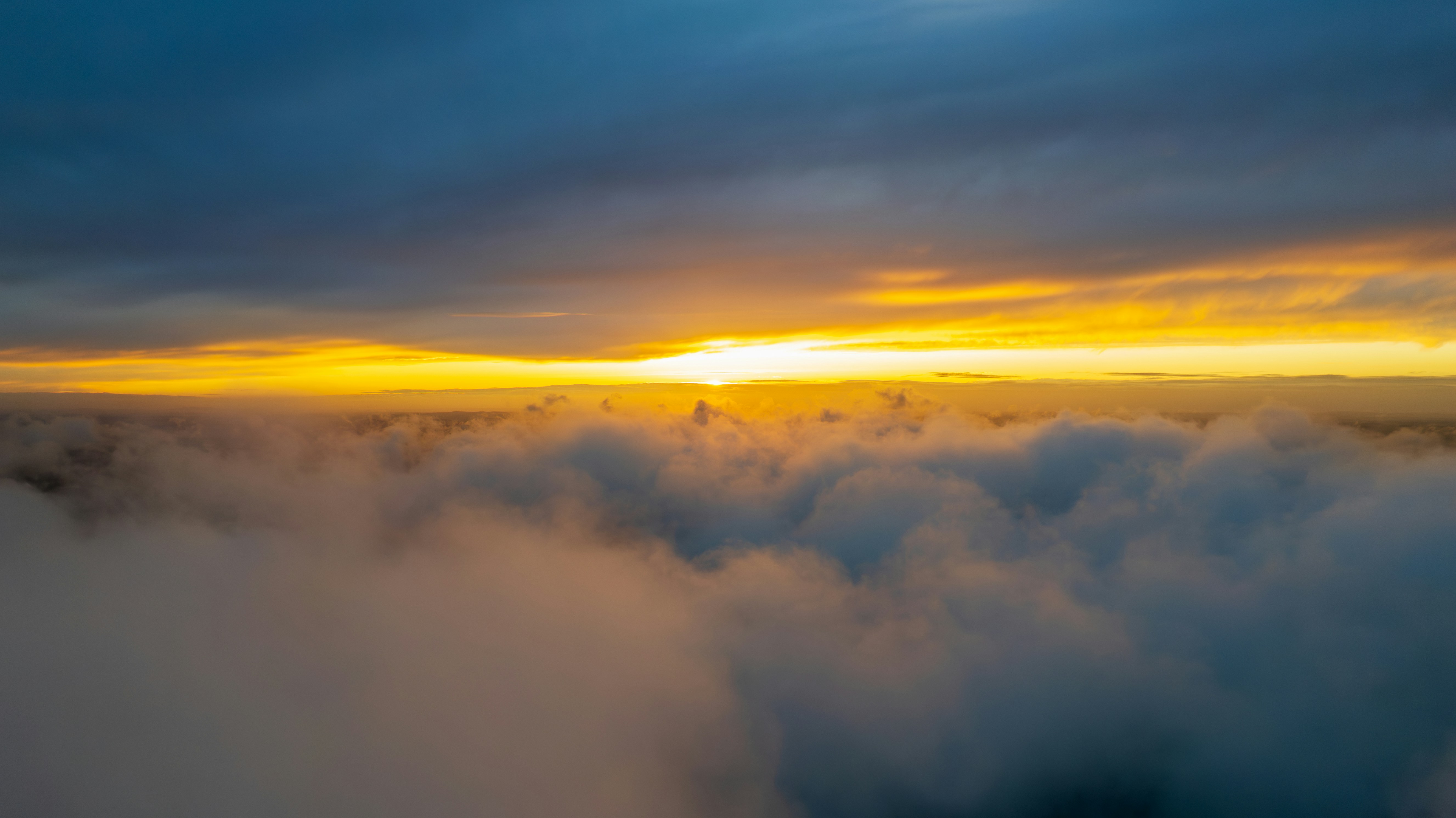 the sun is setting over the clouds in the sky