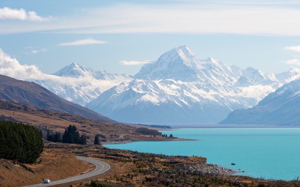 a scenic view of a mountain range with a lake in the foreground