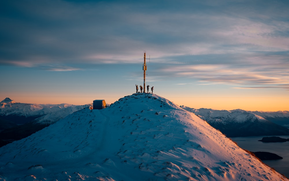 a group of people standing on top of a snow covered mountain