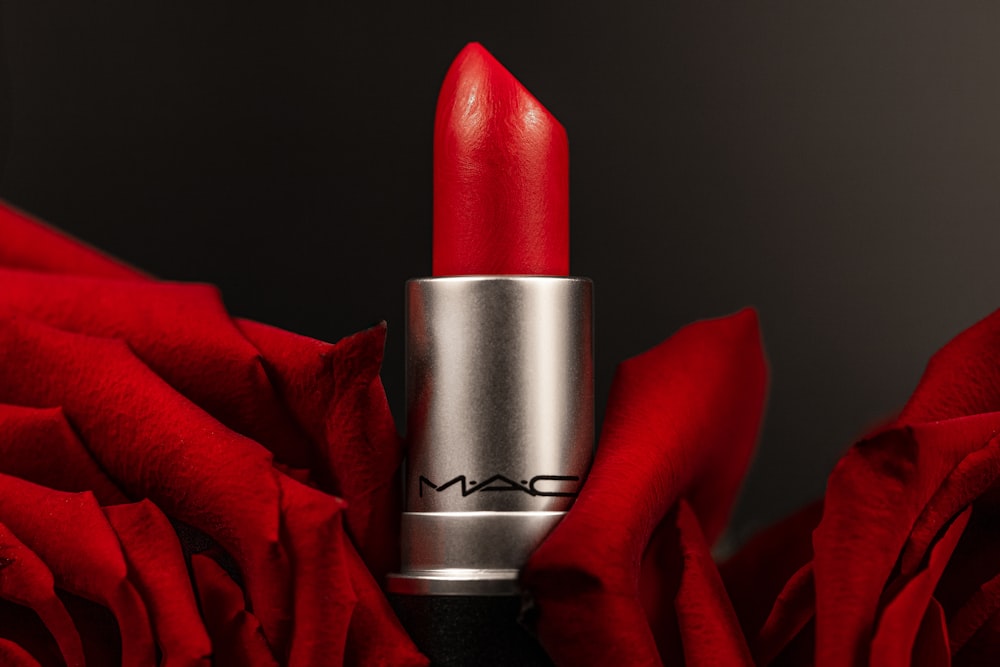 a close up of a lipstick on a red rose