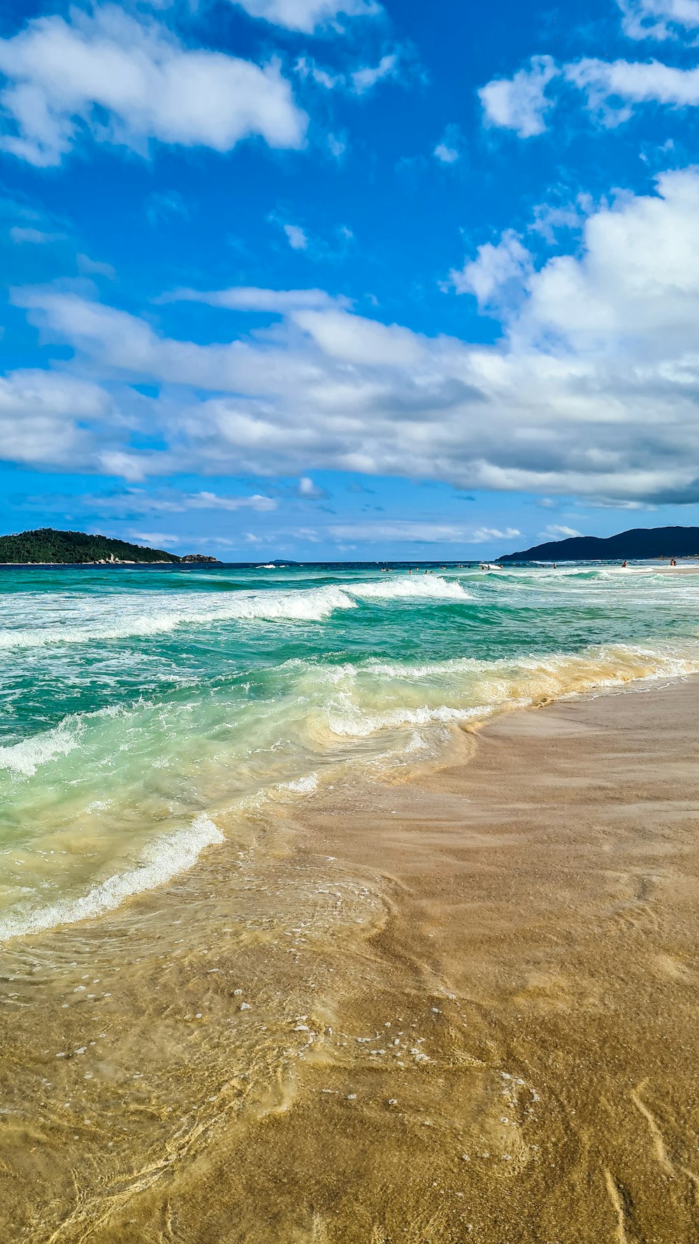 una playa de arena con olas que llegan a la orilla