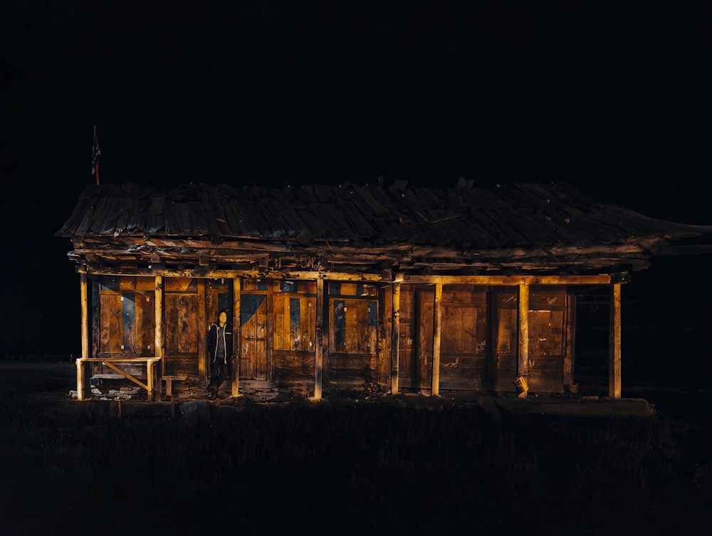 a small wooden building lit up at night