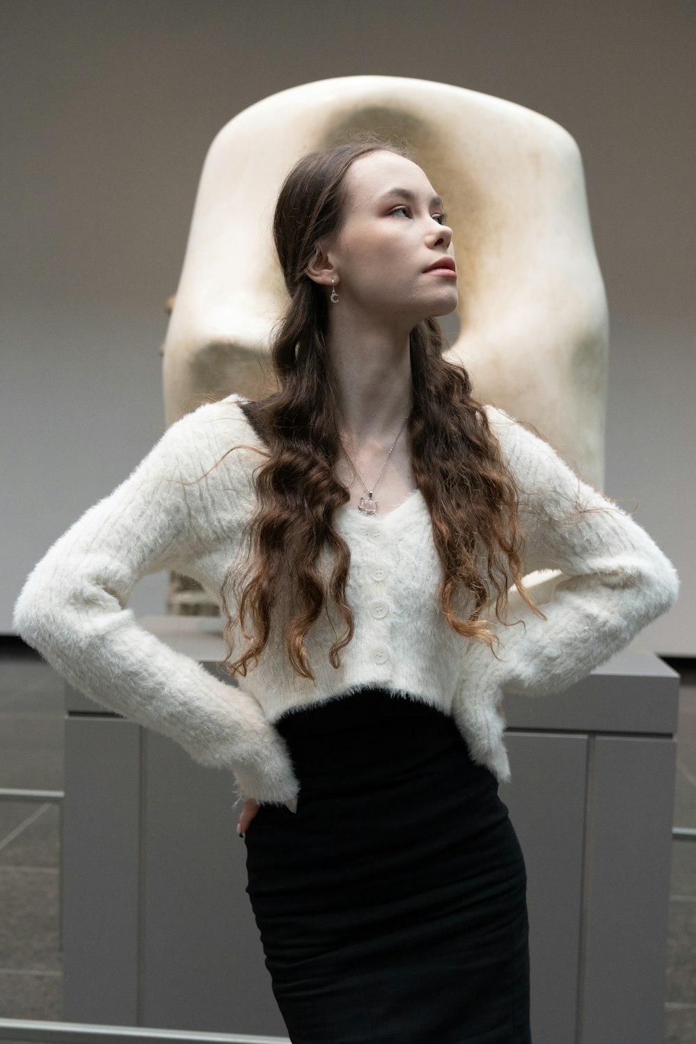 a woman standing in front of a sculpture