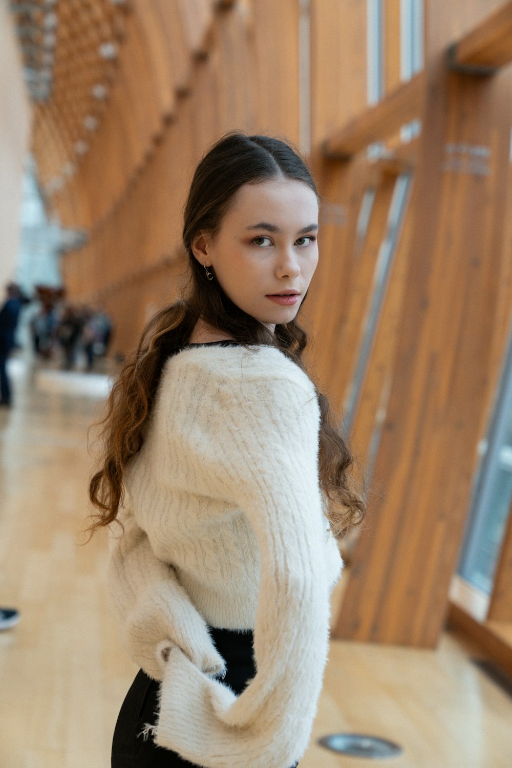 a girl in a white sweater and black pants