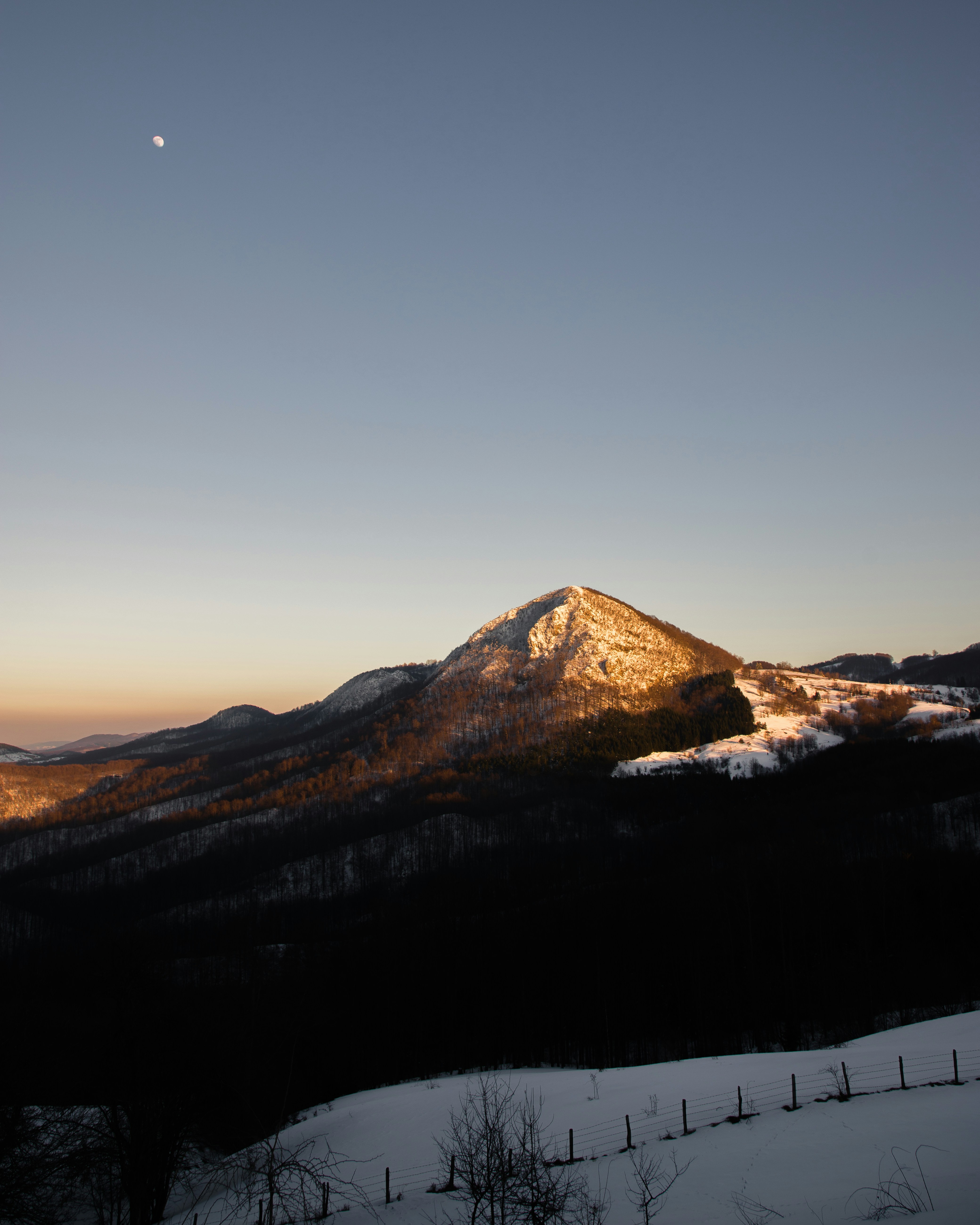 une vue d’une montagne avec une lune dans le ciel