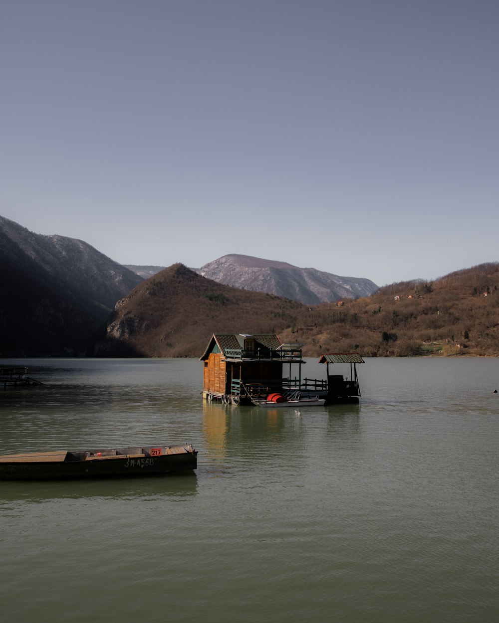 a boat floating on top of a lake next to a house