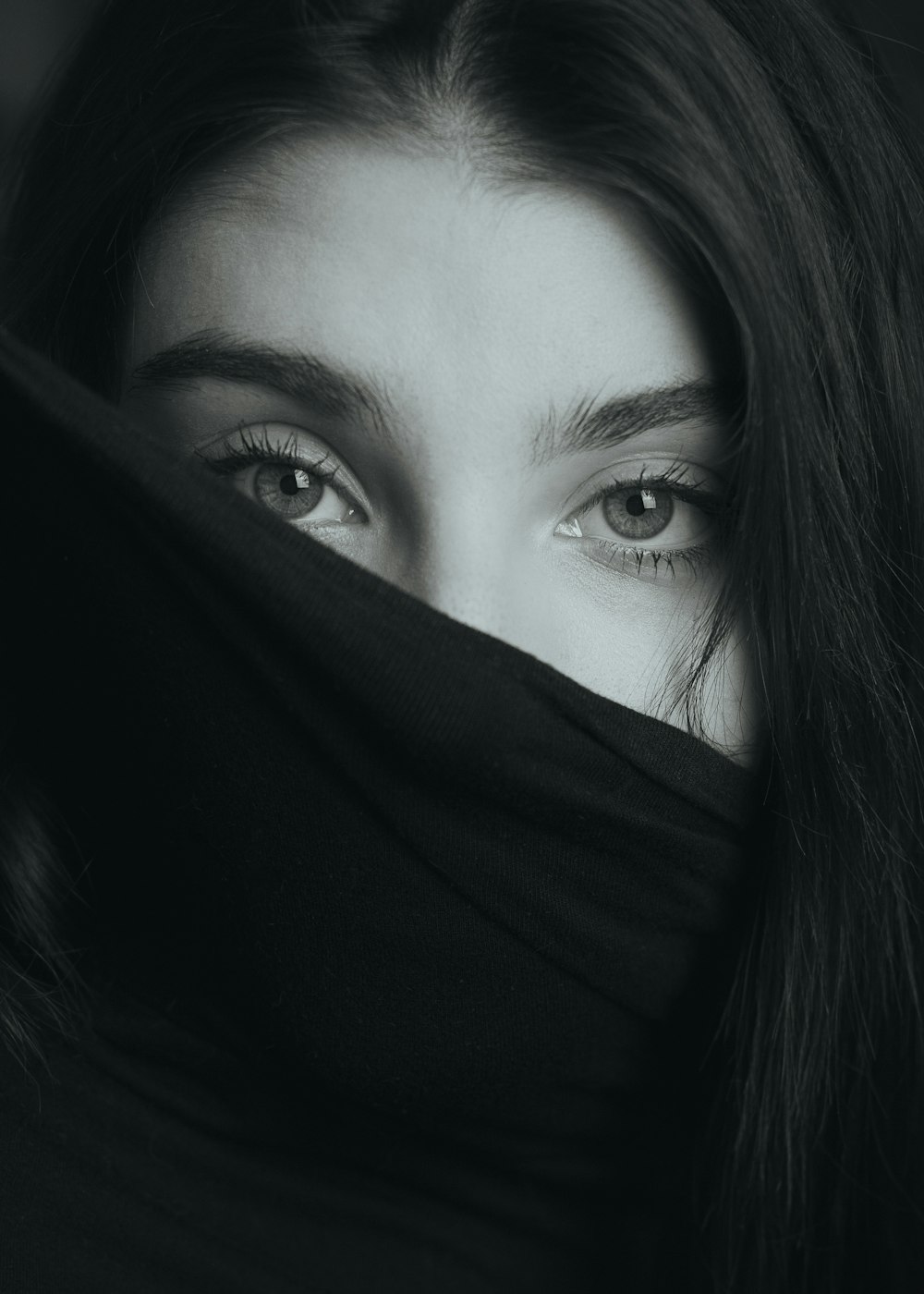 a close up of a person with a scarf over their face
