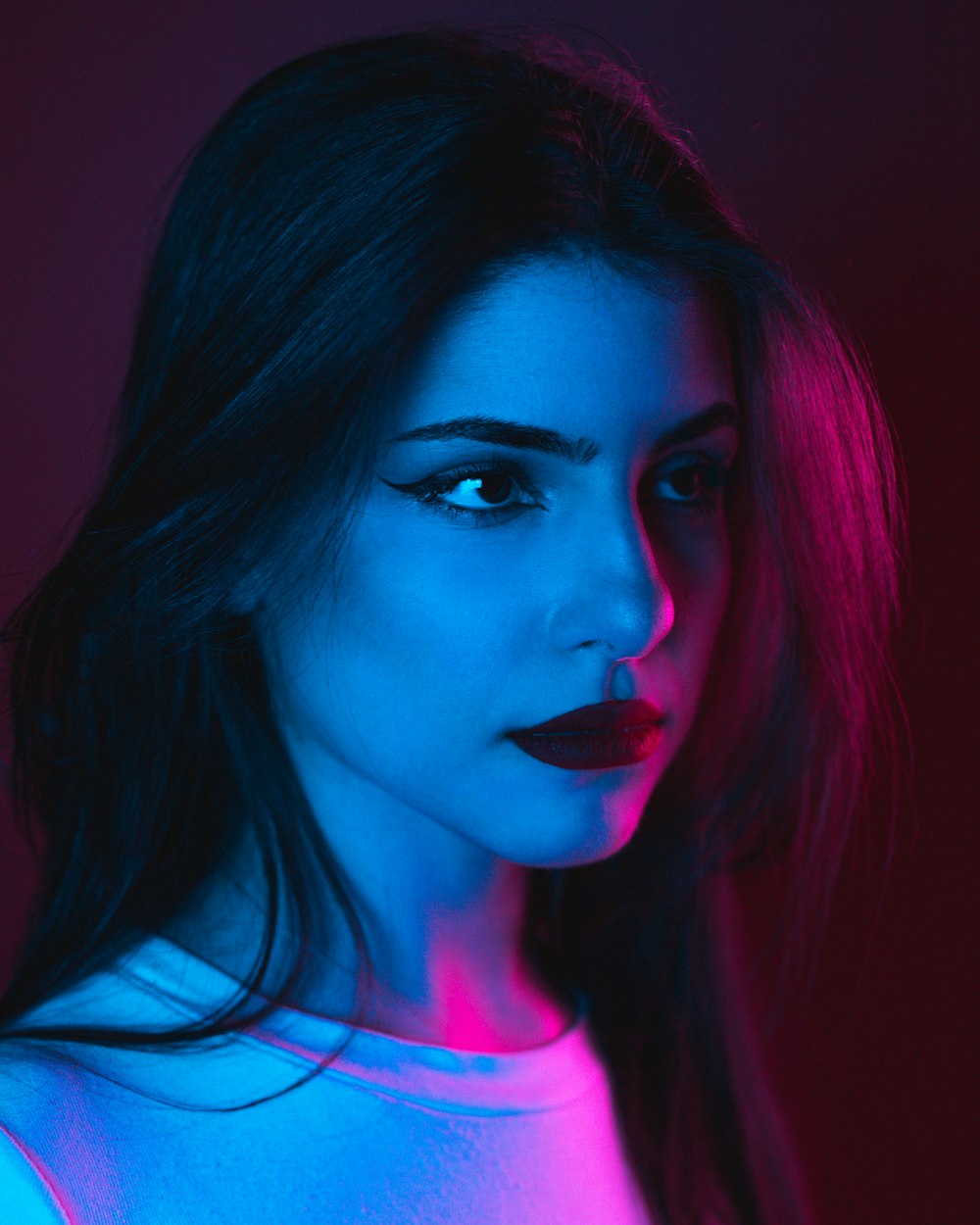 a woman with blue and pink lighting on her face