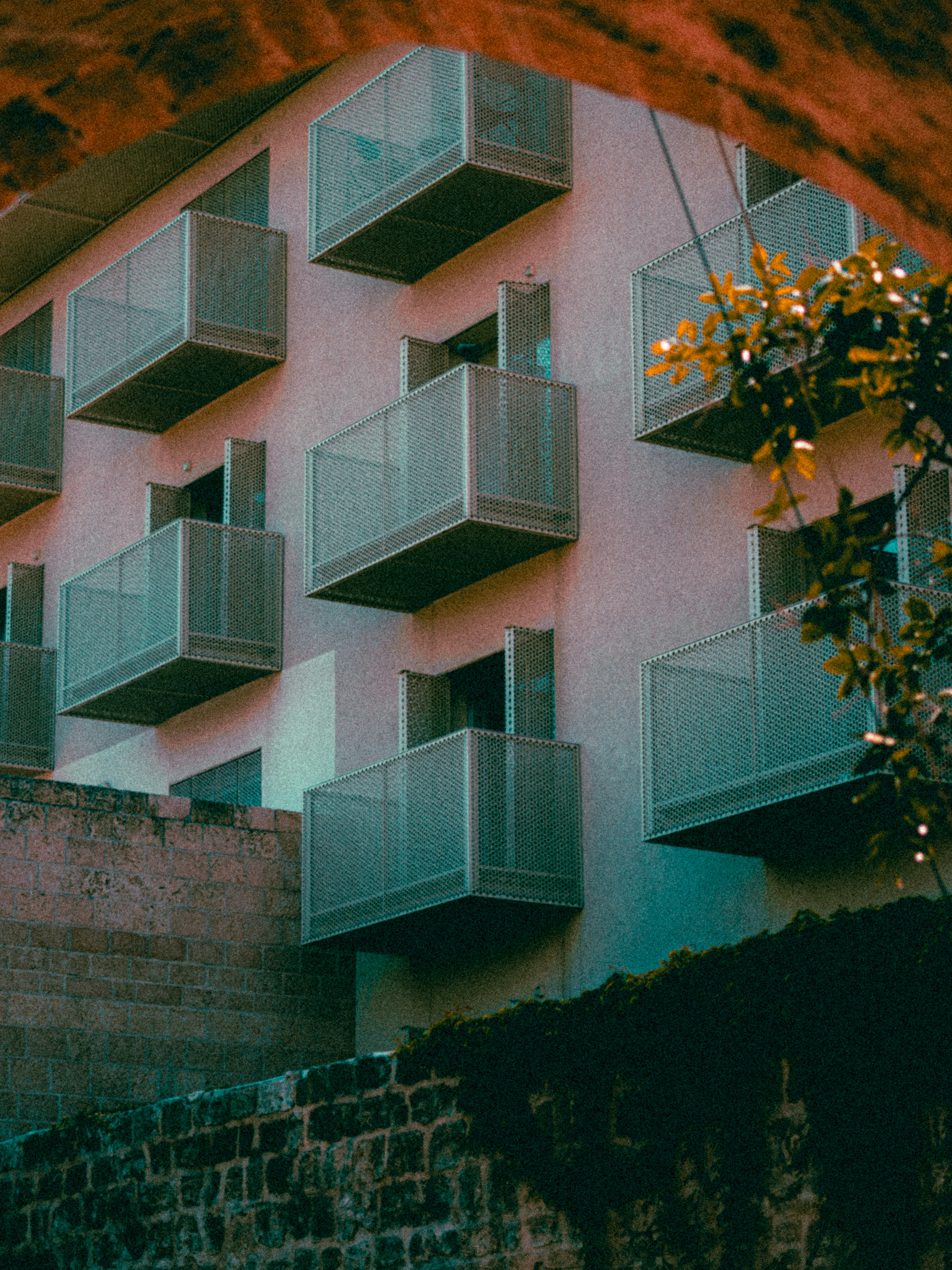 um edifício rosa com varandas e varandas nas varandas