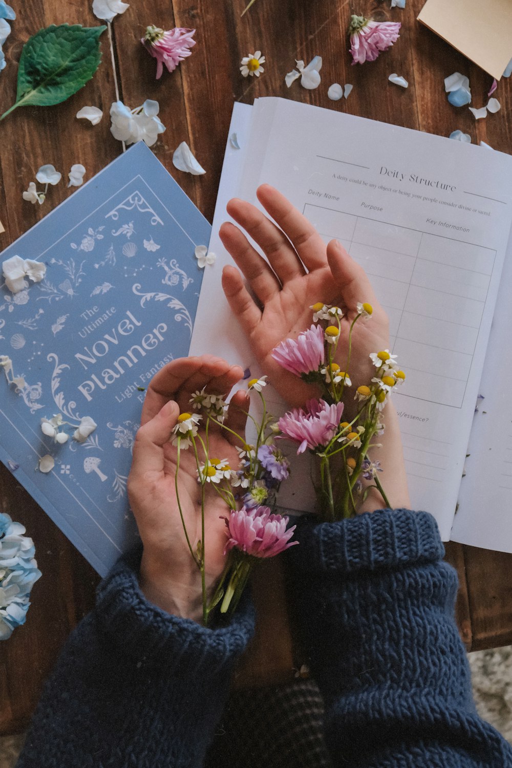 a person holding flowers next to a book