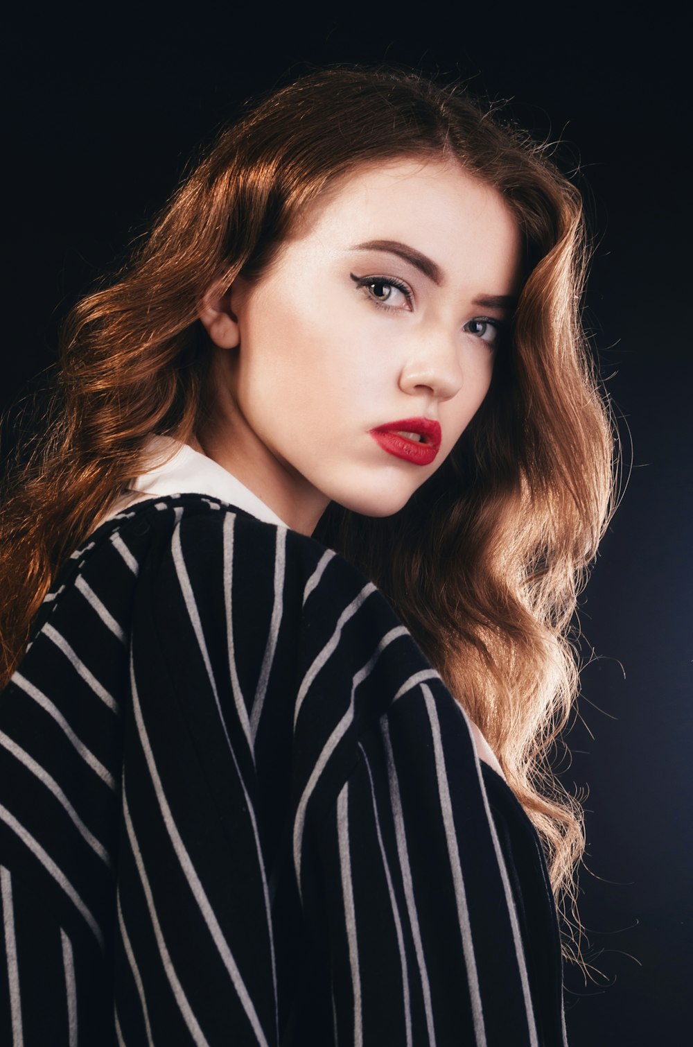 a woman with red lipstick and a striped shirt