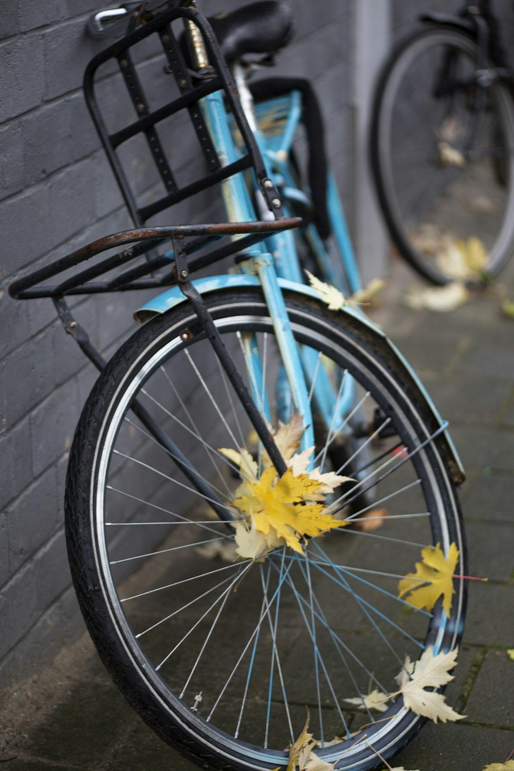 a blue bicycle parked next to a brick wall