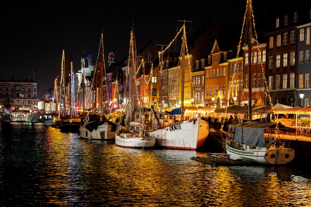 a harbor filled with lots of boats next to tall buildings