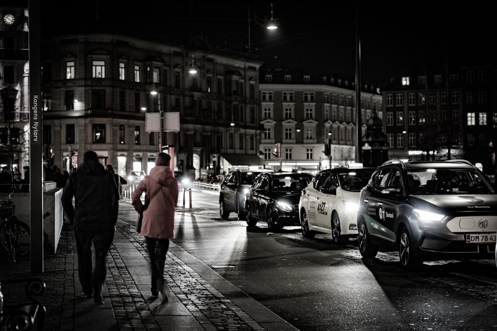 a black and white photo of a city street at night