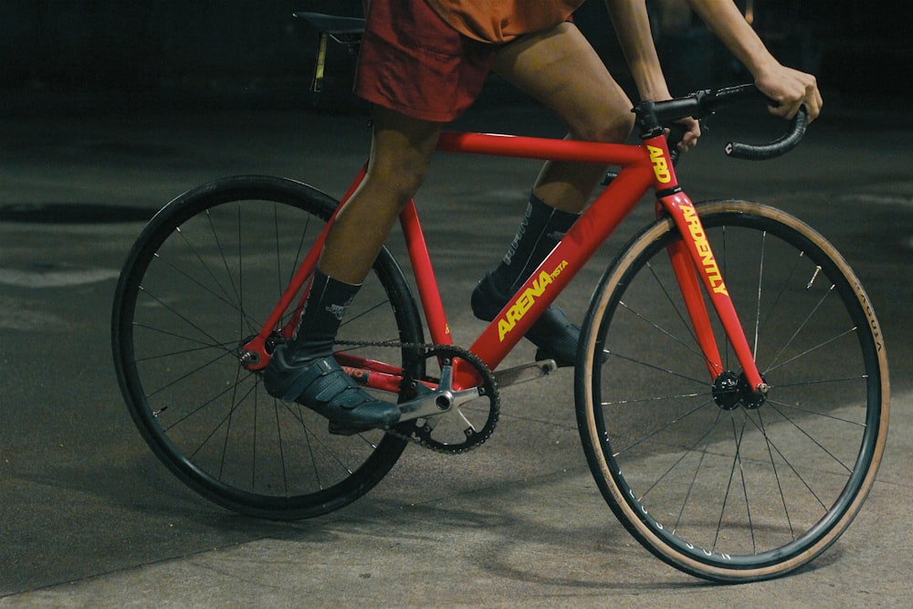 a man riding a red bike down a street