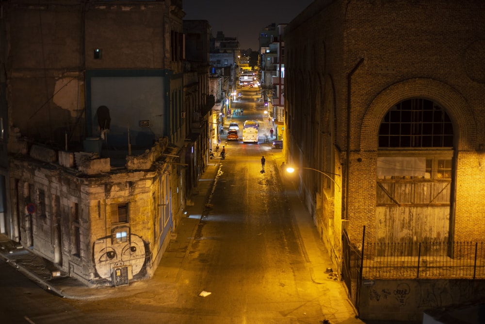 a city street at night with a person walking down the street