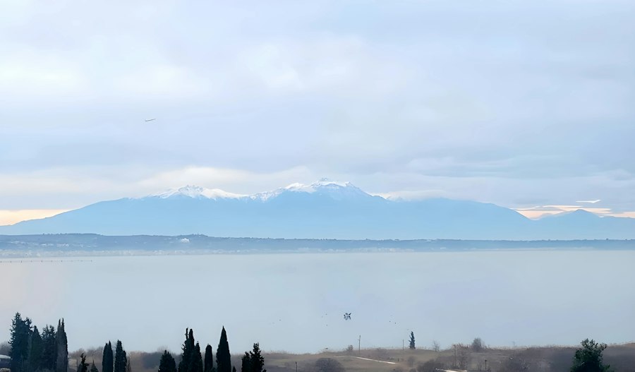 The sea and coastal plain below the forested slopes of Mount Olympus