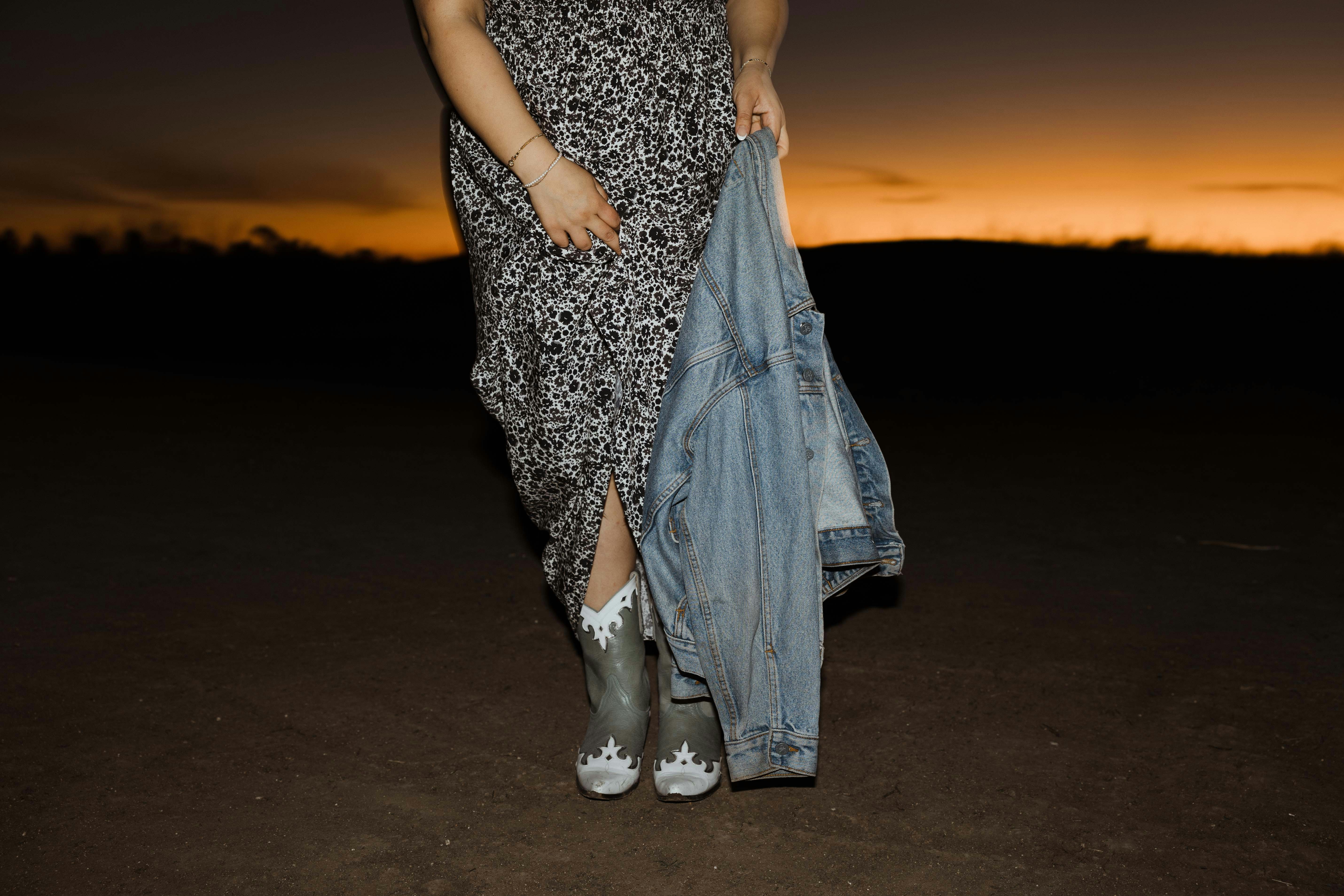 a woman in a dress holding a jean jacket