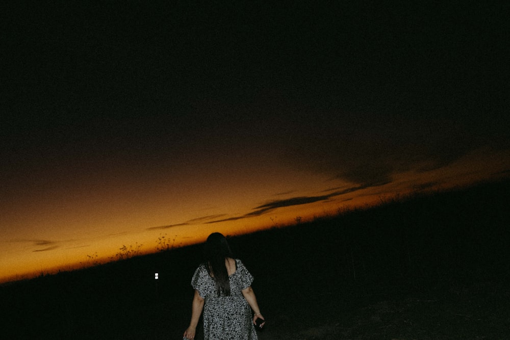 una donna in piedi in un campo di notte