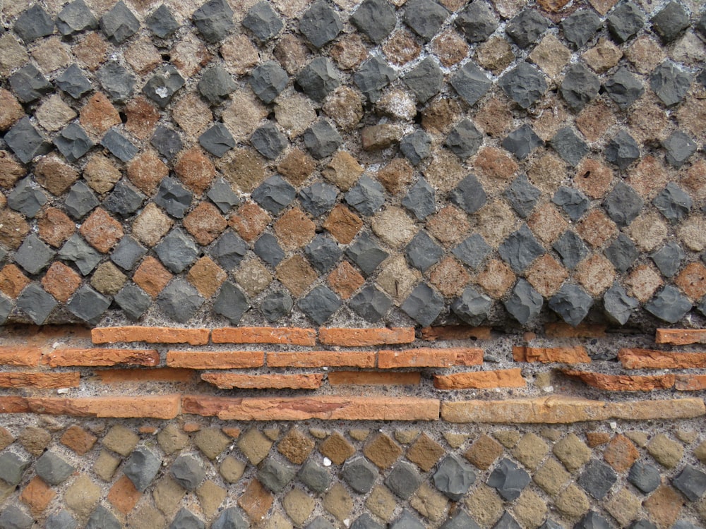 a close up of a brick wall with a bench
