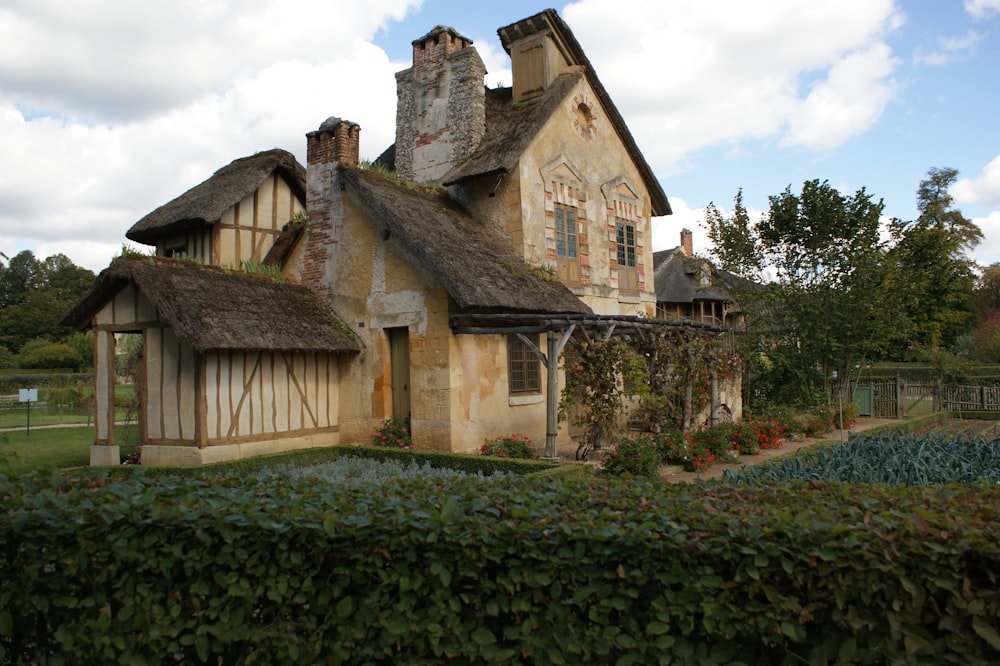 a house with a thatched roof and a garden in front of it