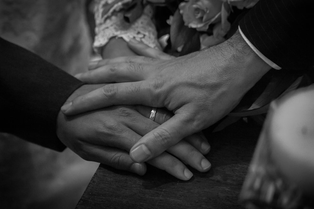 a close up of two people holding hands