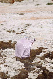 a striped shirt is laying on a rock