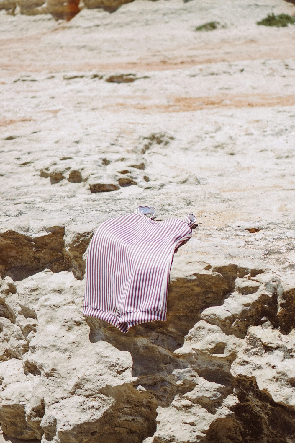 a striped shirt is laying on a rock