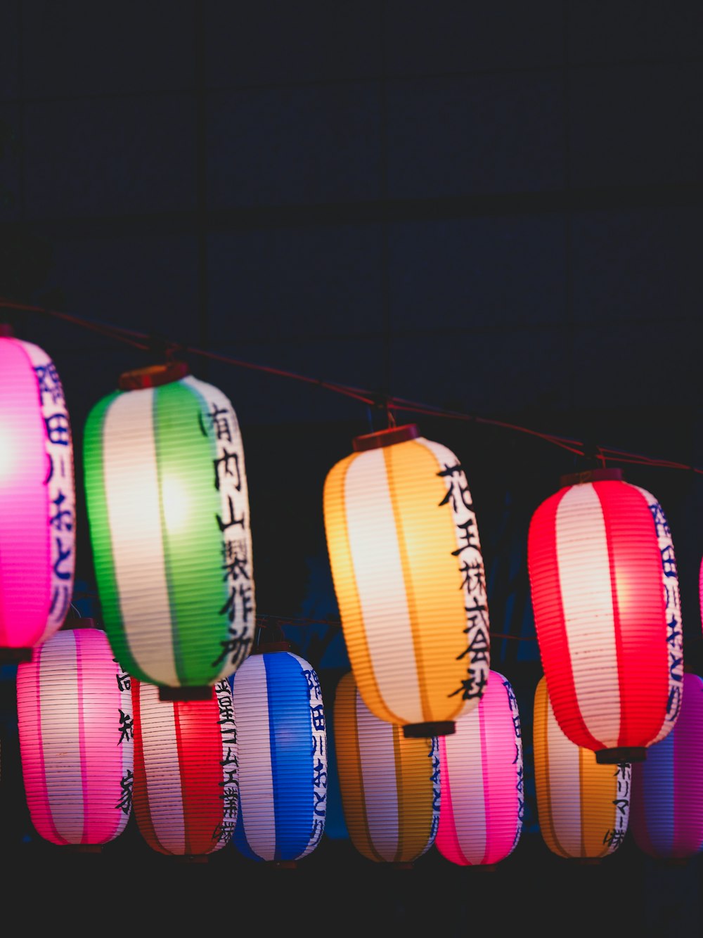 a row of multicolored paper lanterns hanging from a line