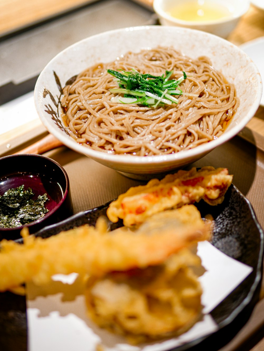 a bowl of noodles and other foods on a tray