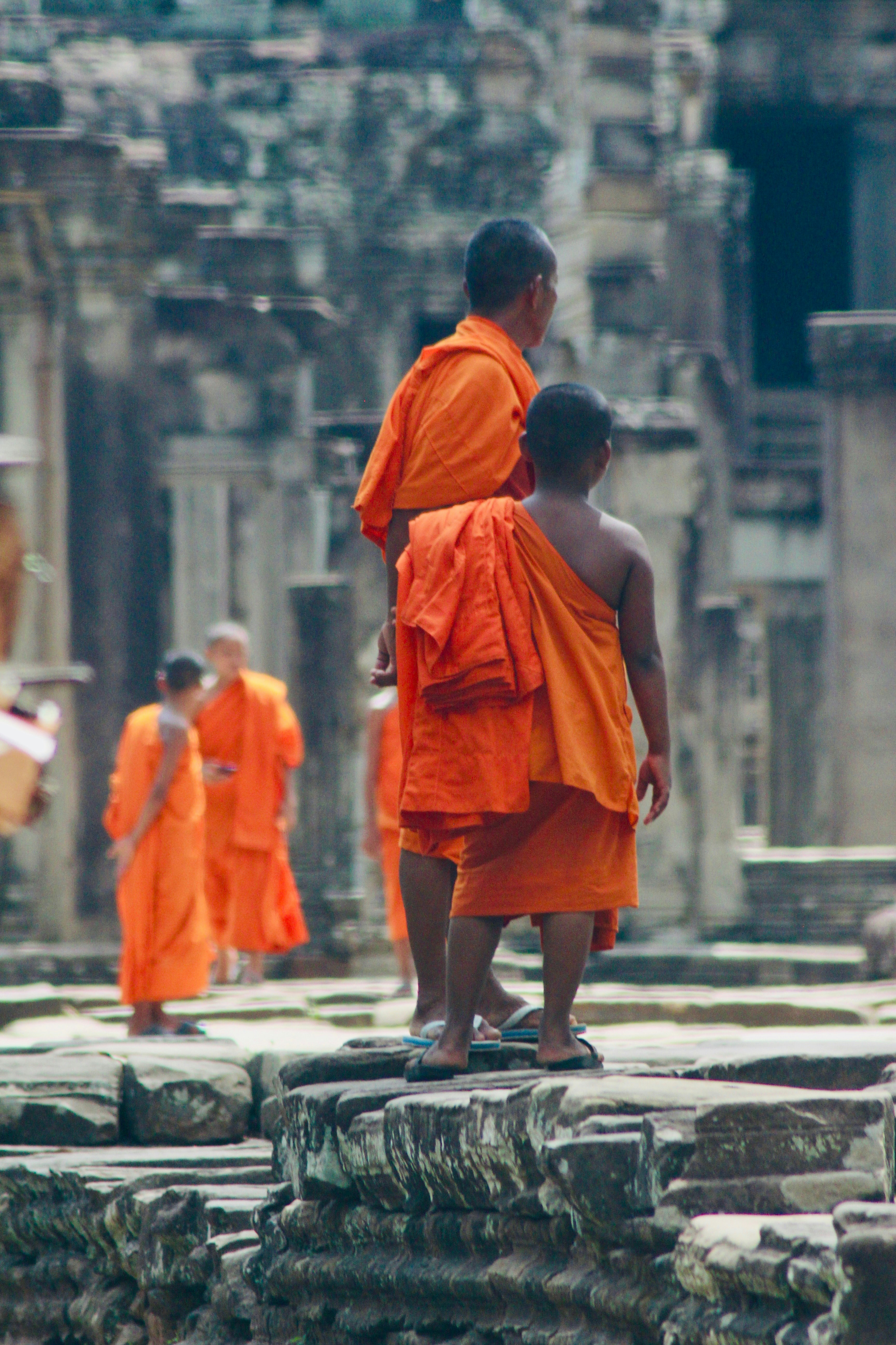 Un grupo de monjes con túnicas naranjas de pie frente a un edificio