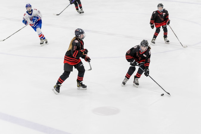 Youth hockey players compete on the ice in full gear, part of the Education and Youth Sports programs backed by the foundations