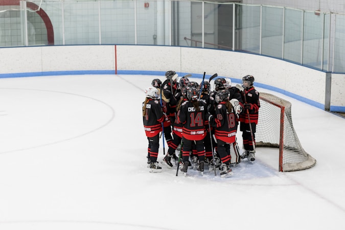 A group of hockey players huddled together on the ice before a face-off