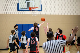 a group of young men playing a game of basketball