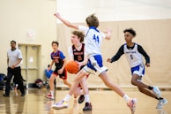 a group of young men playing a game of basketball
