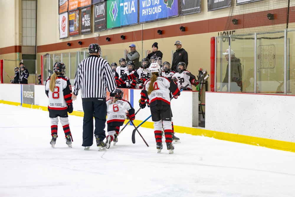 a group of young people playing a game of ice hockey