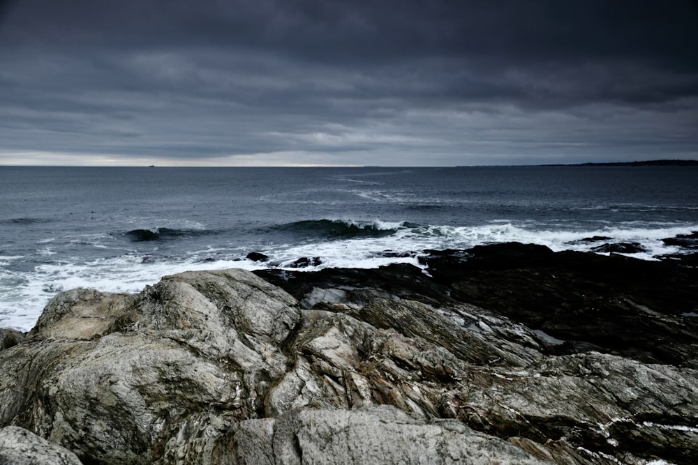 a large body of water sitting next to a rocky shore