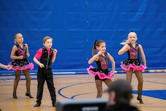 a group of young girls standing on top of a basketball court