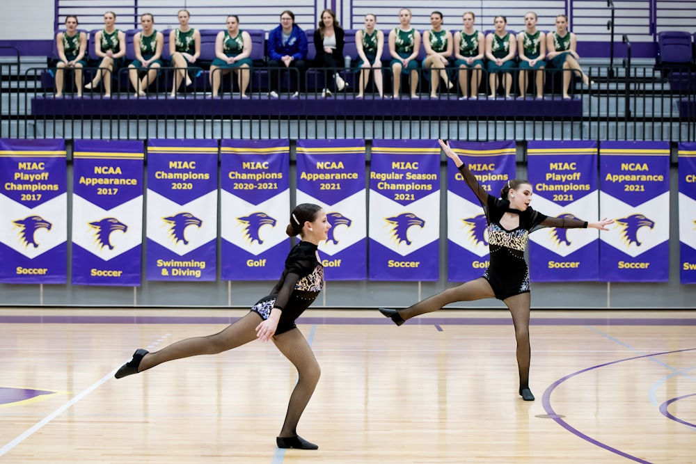 a couple of women standing on top of a basketball court