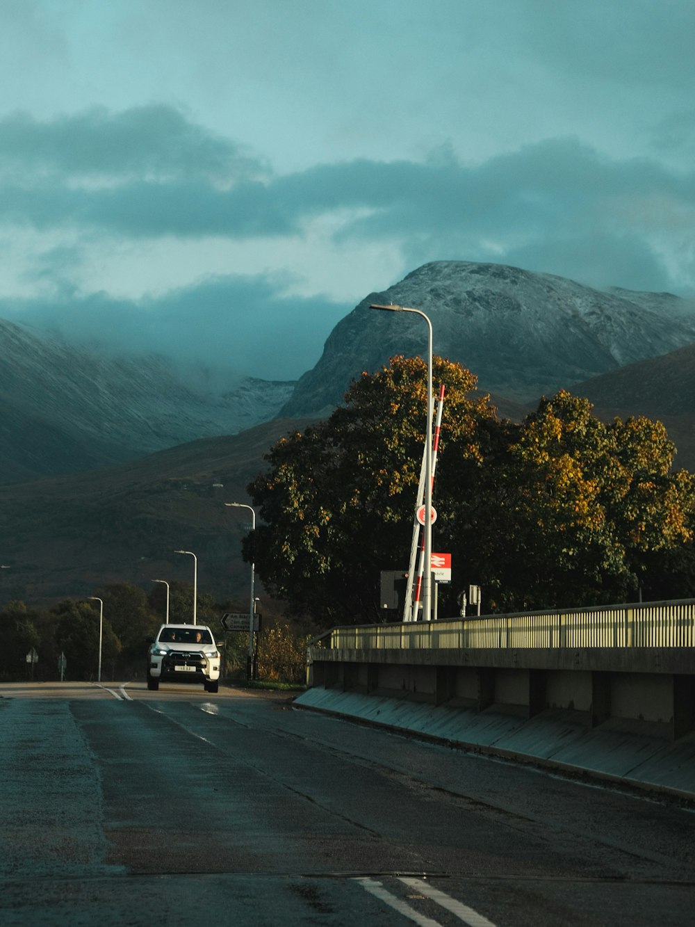 a car driving down a road with a mountain in the background