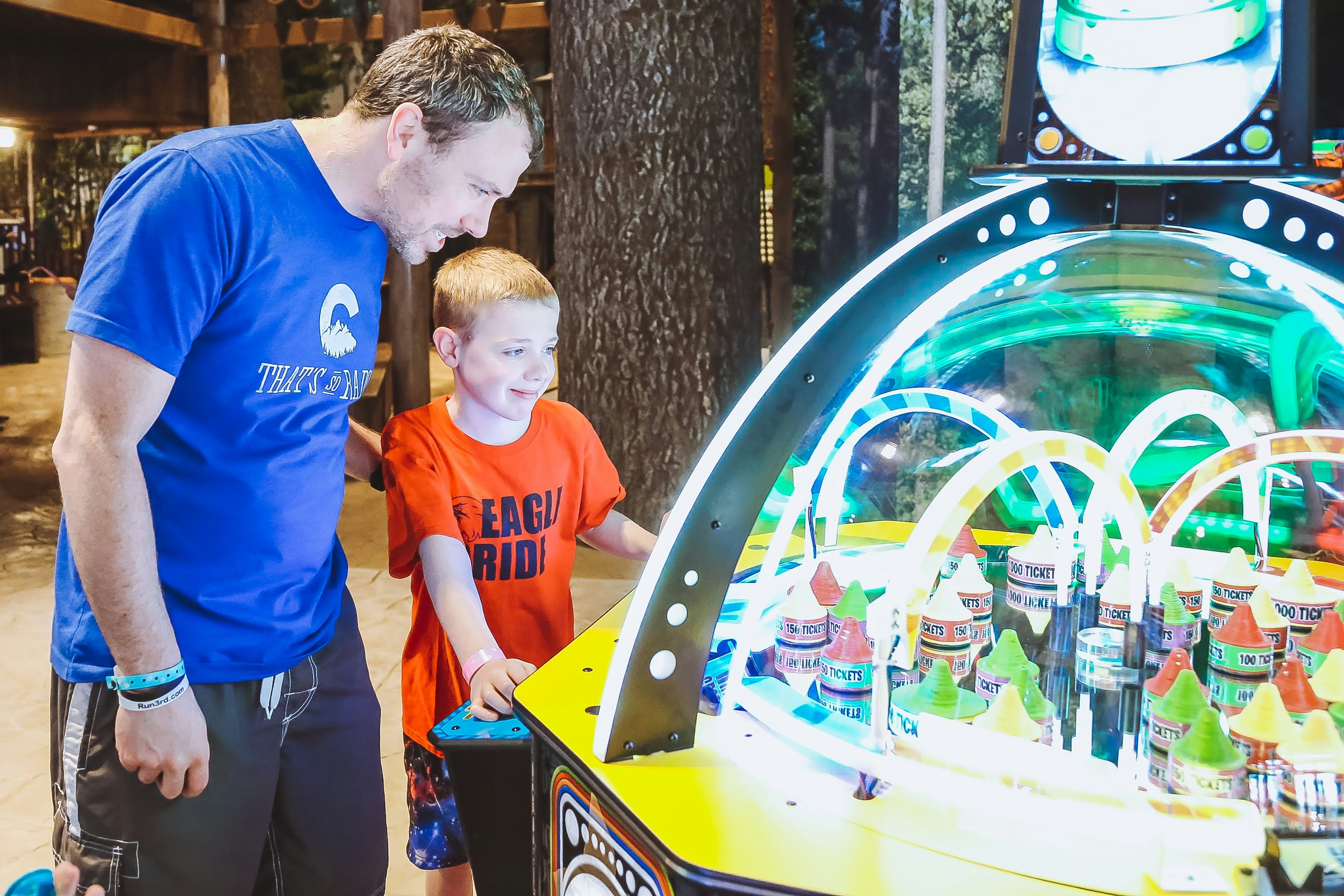 a man and a boy playing a game of pinball