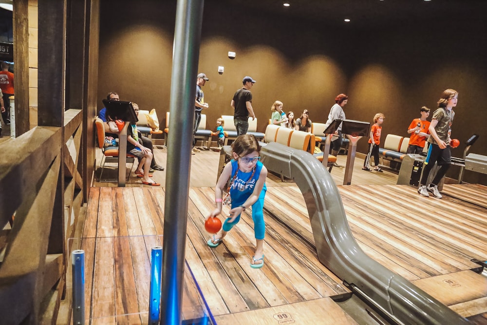 a group of children playing basketball on a wooden floor